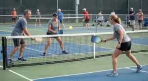 Beginner pickleball players competing in a doubles game on an outdoor court
